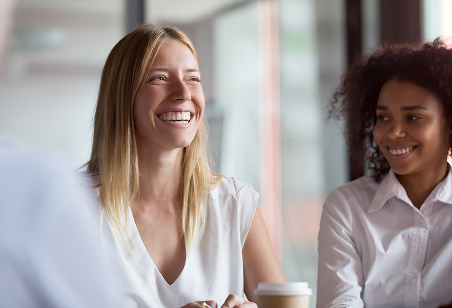 Two women smiling in meeting