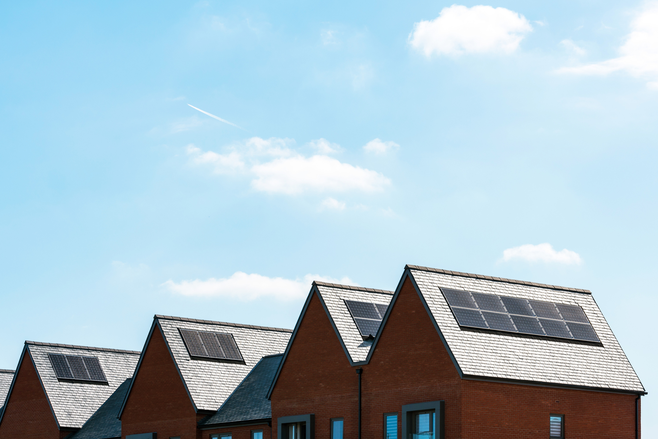 solar panels on roof of new houses in England uk on bright sunny day.