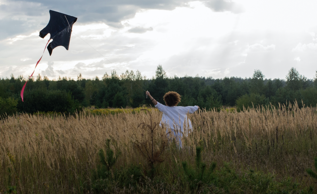Girl running with kite in field