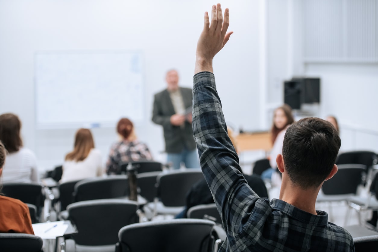 Guy putting hand up at lecture