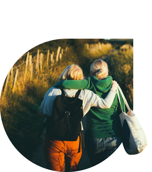 Two friends walking arm in arm