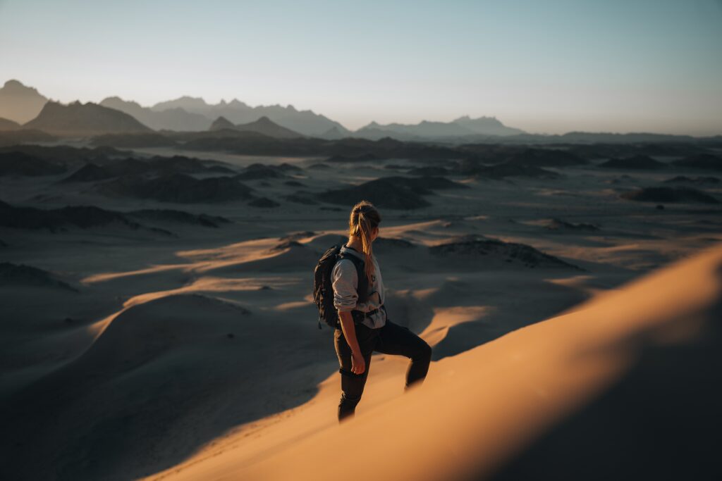 Woman climbing sand dunes